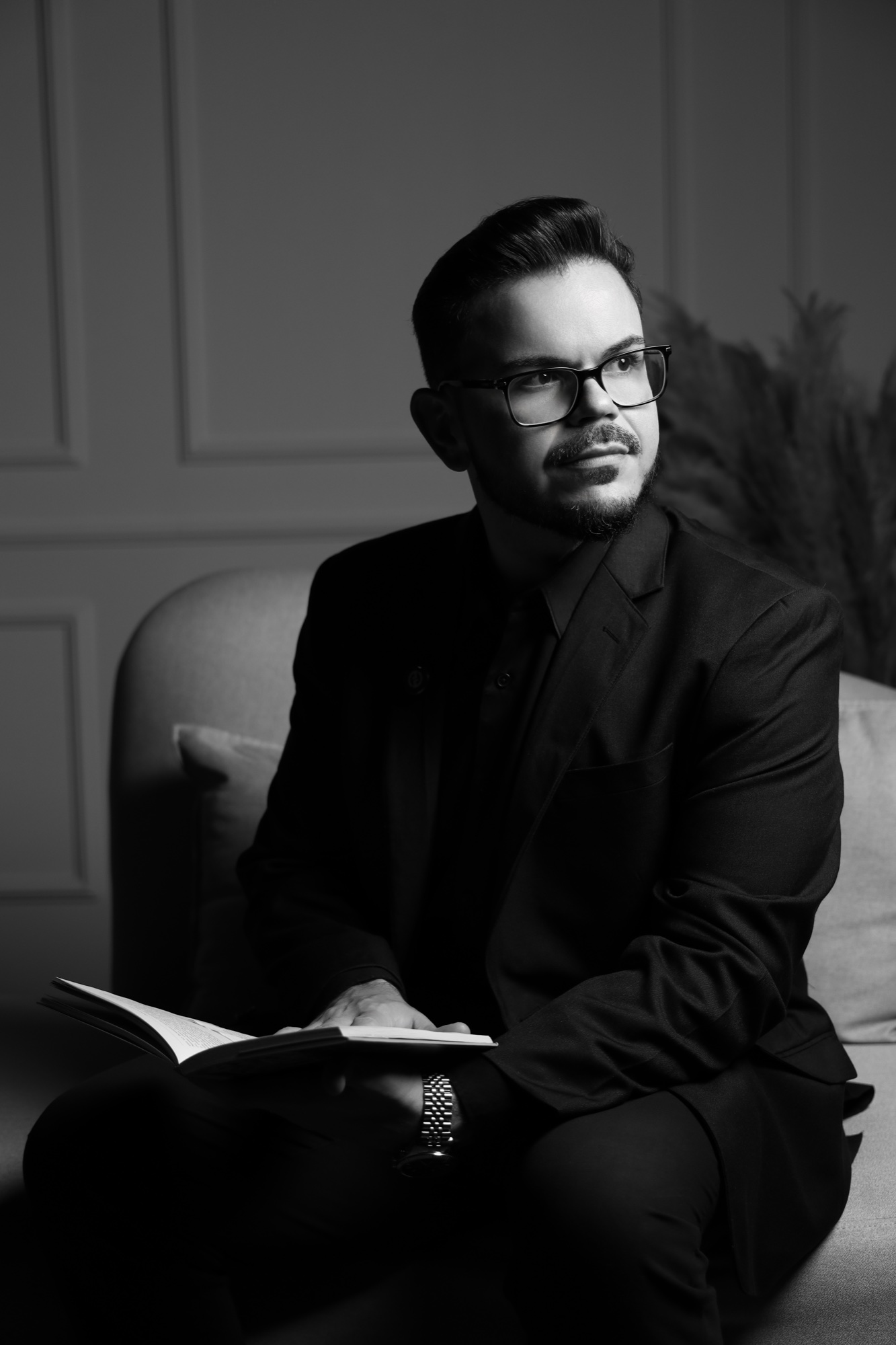 Dr. Marcos André sentado com um livro aberto